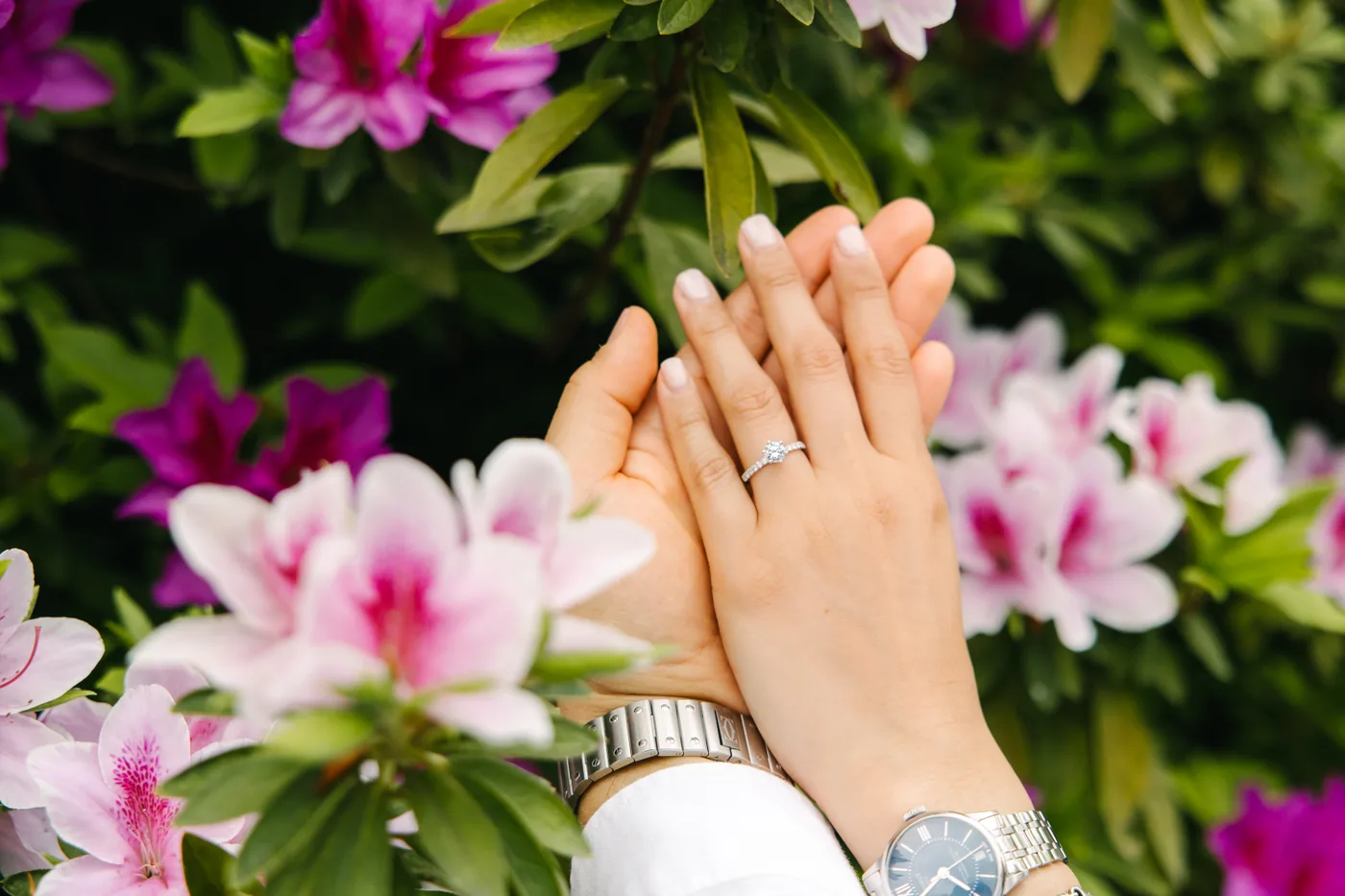 Las manos de Juanita y David con el anillo entre flores